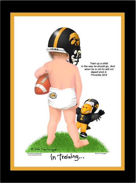 Iowa Hawkeye baby football player wearing a helmet and training pants, holding a football under one arm and a toy hawk with the other hand.